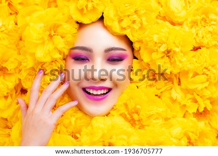 Colorful fashion makeup Asian woman happy smile with yellow flower.