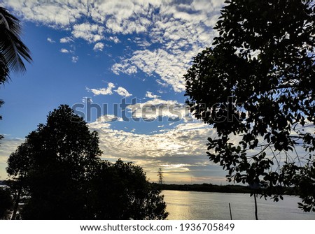 Morning view of sky, river and tree silhouettes. Slightly blurred concept and select focus.