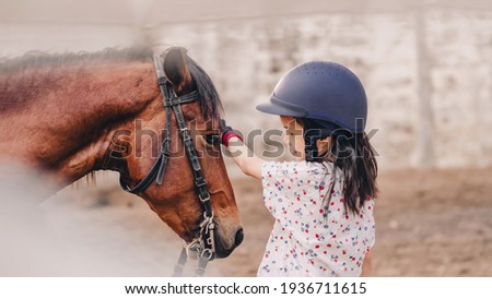 Asian school kid girl with horse, riding or practicing horse riding at a horse ranch
