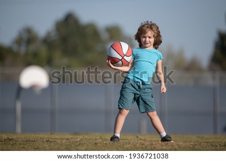 Child boy preparing for basketball shooting. Kid posing with a basketball ball