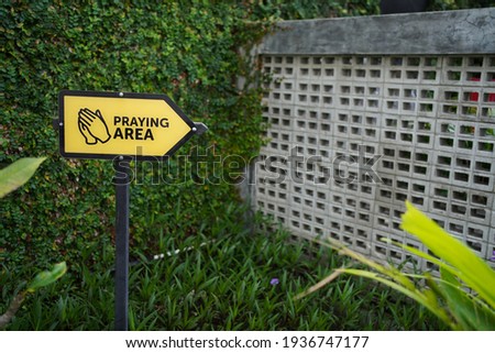 praying area sign with yellow color and green background color