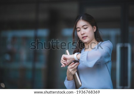 young professional business worker woman checking a time late on hand watch, working day in city urban in concept of busy and confidence, female businesswoman looking clock, time late