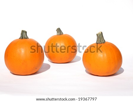 three small pumpkins for halloween or thanksgiving on white