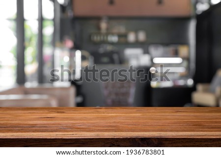 Empty wooden table with blurred background of cafe and restaurant.