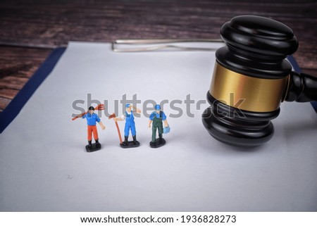 Selective focus image of gavel with miniature of labor. Labor law concept.  Royalty-Free Stock Photo #1936828273