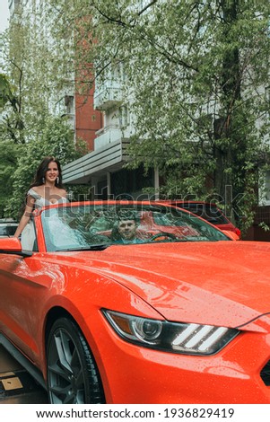 A Happy newlyweds go to the celebration in a red car with an open top. Wedding Concept