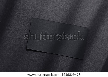 Black business card on dark flatlay background and sunlight shadows, luxury branding flat lay and brand identity design for mockups
