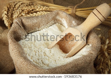 Flour in burlap bag and wooden spoon Royalty-Free Stock Photo #193683176