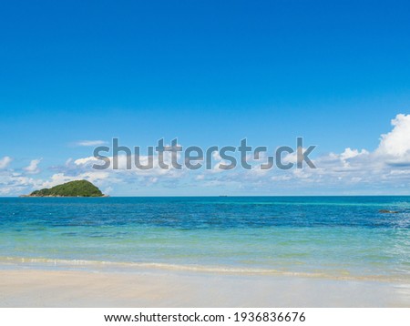 front view where the ocean waves are blowing to the shore. On the beach of Nang Ram Beach With bright skies, white clouds, and small distant islands behind. Suitable for traveling Rest on vacation