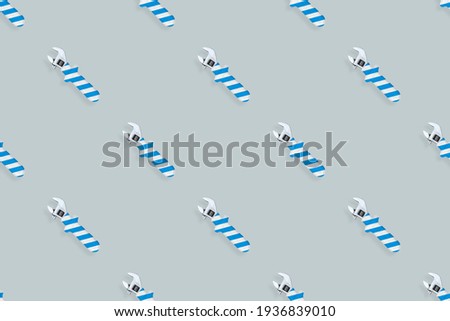 Adjustable wrench seamless pattern. Background made of a metal adjustable wrench with a rubber striped handle. 
