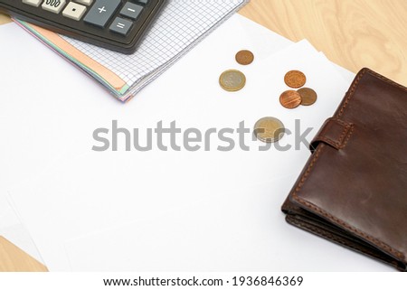 calculator wallet and coins are on the table. High quality photo