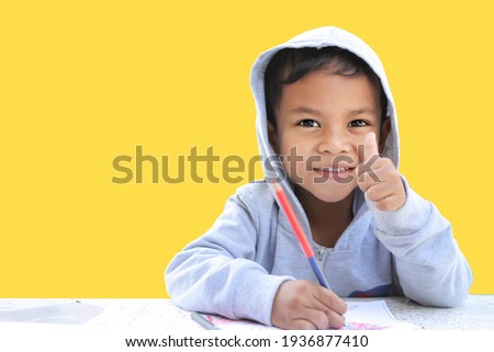 Portrait of the happy smiling child on the isolated yellow background. chipping path.