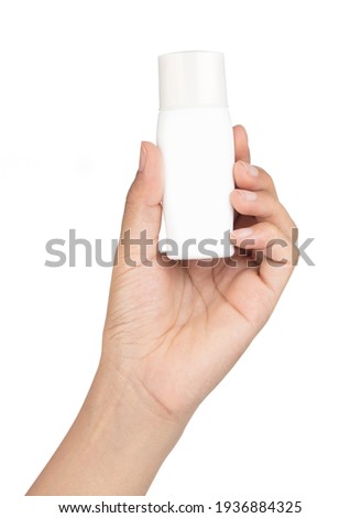 Hand holding sunscreen bottle isolated on white background. Royalty-Free Stock Photo #1936884325