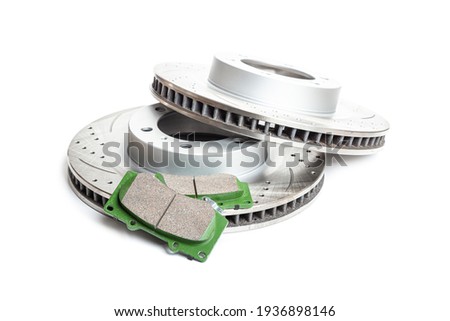 Perforated  brake pads next to brake disc on white background isolated object