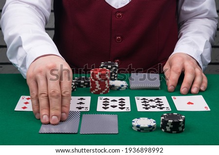 the dealer's hands open cards on the green poker table