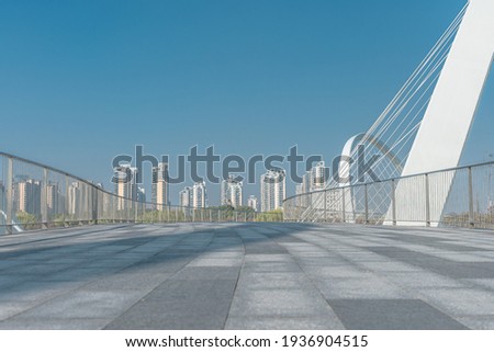 A modern pedestrian bridge in a park. Royalty-Free Stock Photo #1936904515