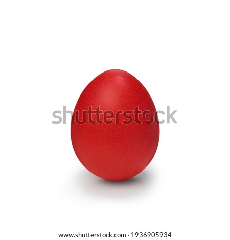 Red easter egg isolated on white background. Chicken egg painted in red color stands on surface, close up. Beautiful object for design to easter holiday