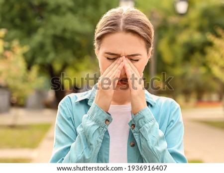 Young woman suffering from allergy outdoors Royalty-Free Stock Photo #1936916407