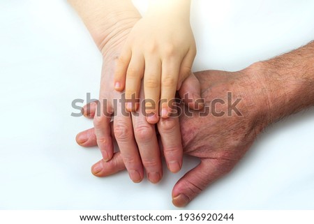 Little kids grandson hands on old hands of grandparents. Concept assistance, patronage and generation. National Senior Citizens Day. World Humanitarian Day Royalty-Free Stock Photo #1936920244
