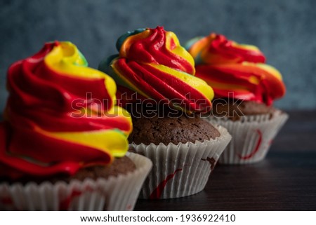 Cupcakes covered with rainbow frosting. Muffin with rainbow icing. Colorful icing cakes.