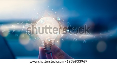 Hand holding light bulb with media icon on digital innovation and creativity are keys to success. Concept knowledge leads to ideas and inspiration. Royalty-Free Stock Photo #1936933969