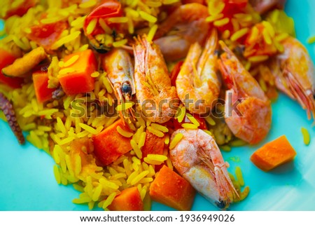 Sea food paella dish cooked with traditional Mediterranean recipe for lunch.Prawns,mussels and spicy rice served on plate in Spanish restaurant.Curated collection of royalty free images of seafood