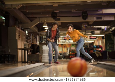Young couple having fun in bowling alley.  Focus is on couple.