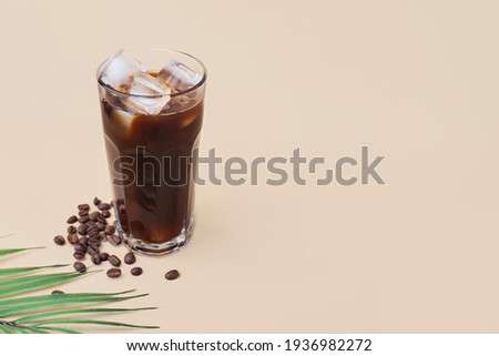 cold iced black coffee with on a beige background, summer drink Royalty-Free Stock Photo #1936982272