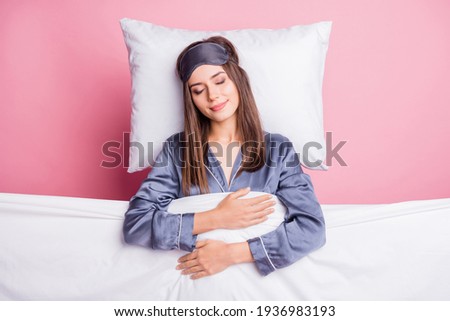 Photo portrait of girl wearing nightwear sleeping under soft blanket in bed isolated on pastel pink color background Royalty-Free Stock Photo #1936983193
