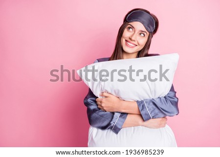 Photo portrait of dreamy girl hugging pillow looking at blank space isolated on pastel pink colored background Royalty-Free Stock Photo #1936985239