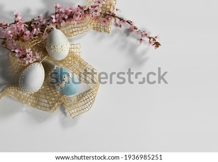 Happy easter frame. Elegant and delicate eggs framed by a branch of cherry blossoms.