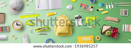 Flat lay top view of face mask and school supplies, back to school and coronavirus concept. Royalty-Free Stock Photo #1936985257