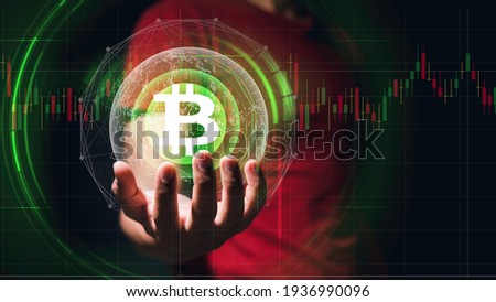 Hand of a businessman is holding a floating gold Bitcoin, virtual money on the black background. With high-tech technology effects. Make money with bitcoin, Blockchain transfer.