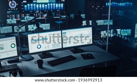 Two Digital Computer Screens with Financial Analytical Data in Modern Monitoring Office. Control Room with Finance Specialists Sit in Front of Computers. Royalty-Free Stock Photo #1936992913