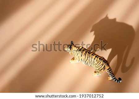 Tiger symbol of the Chinese new year 2022. Figurine of tiger isolated on pastel background with shadows. Copy space.