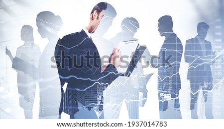 Businessman holding clipboard and taking notes about stock market rate behavior. Financial services consulting. double exposure. Colleagues are on background of financial city center of New York city Royalty-Free Stock Photo #1937014783