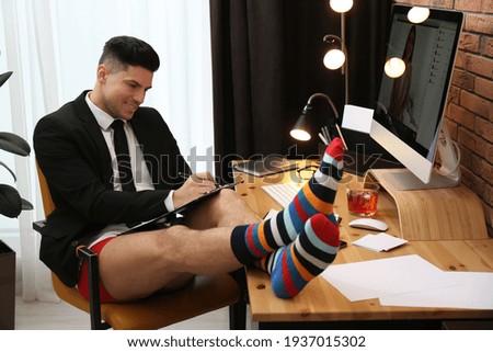 Businessman in jacket and underwear having videocall on computer at home office