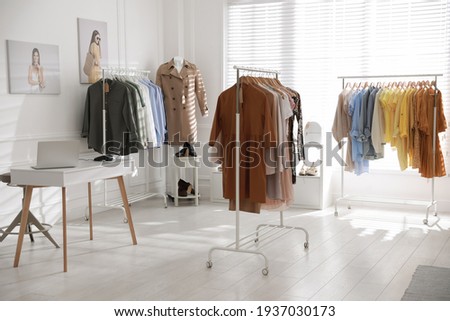 Modern boutique interior with stylish clothes and laptop Royalty-Free Stock Photo #1937030173