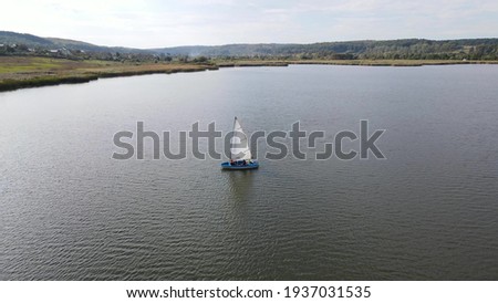 Boat with a white sail on the lake