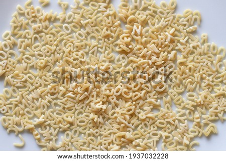 alphabet letters of pasta on a white plate