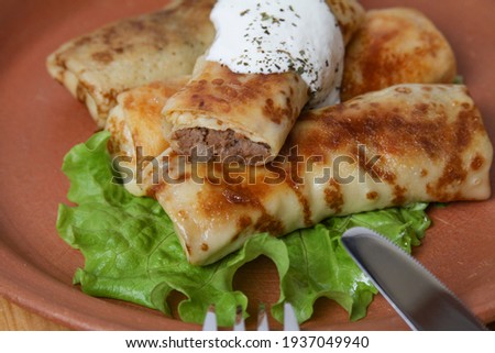 Crepes Stuffed Minced Beef Meat On Clay Plate With Sour Cream. Side View, Close Up.