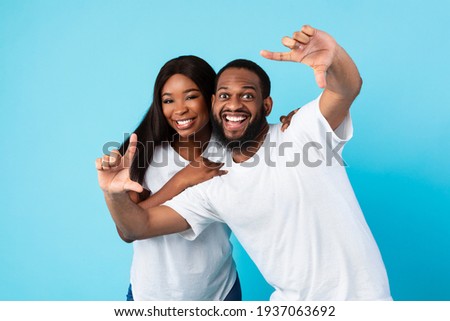 Black couple making picture frame with fingers