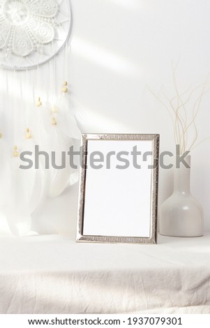 Silver frame with vase and dreamcatcher