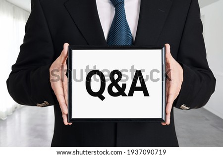 Businessman holds a signboard with the letters Q and A. Questions and answers business or education support concept.
