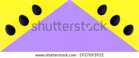 Black eggs on the yellow and violet background. Easter, diversity, geometric, pattern, food concept