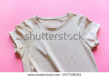 Mockup template of beige T-shirt with blank empty space on pink background.