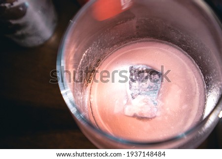 Cocktail cosmopolitan pink ice in a glass bar orange liqueur fresh lime juice cranberry juice