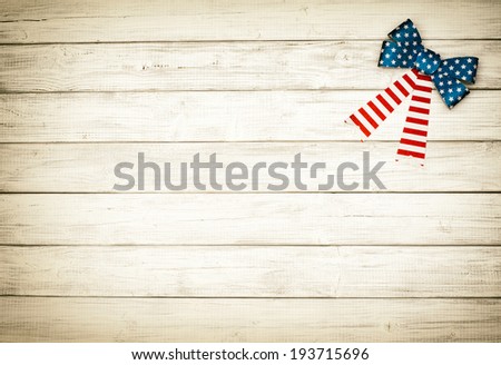 One American Flag Bow in upper right corner on Rustic White or Gray Board Background with room or space for copy, text.   Horizontal with old fashioned, sepia processing.