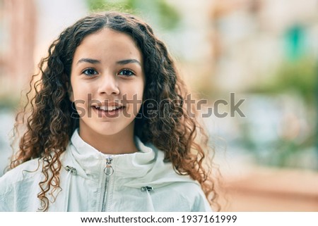 Hispanic teenager girl smiling happy standing at the city.