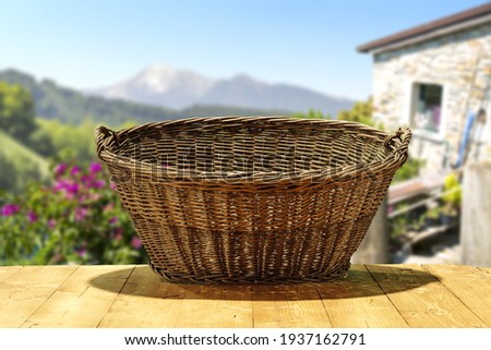 Empty wooden basket on table and summer landscape 